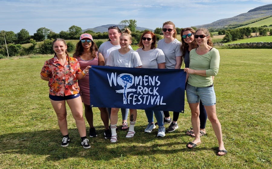 Participants of WRF2022, women climbing and holding the WRF flag